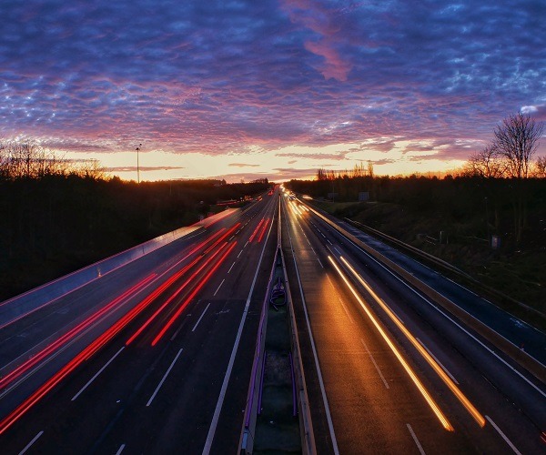 Highway at sunset showing moving vehicle lights